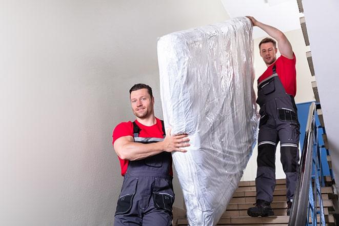 furniture removal experts handling a box spring with care in Port Wentworth, GA